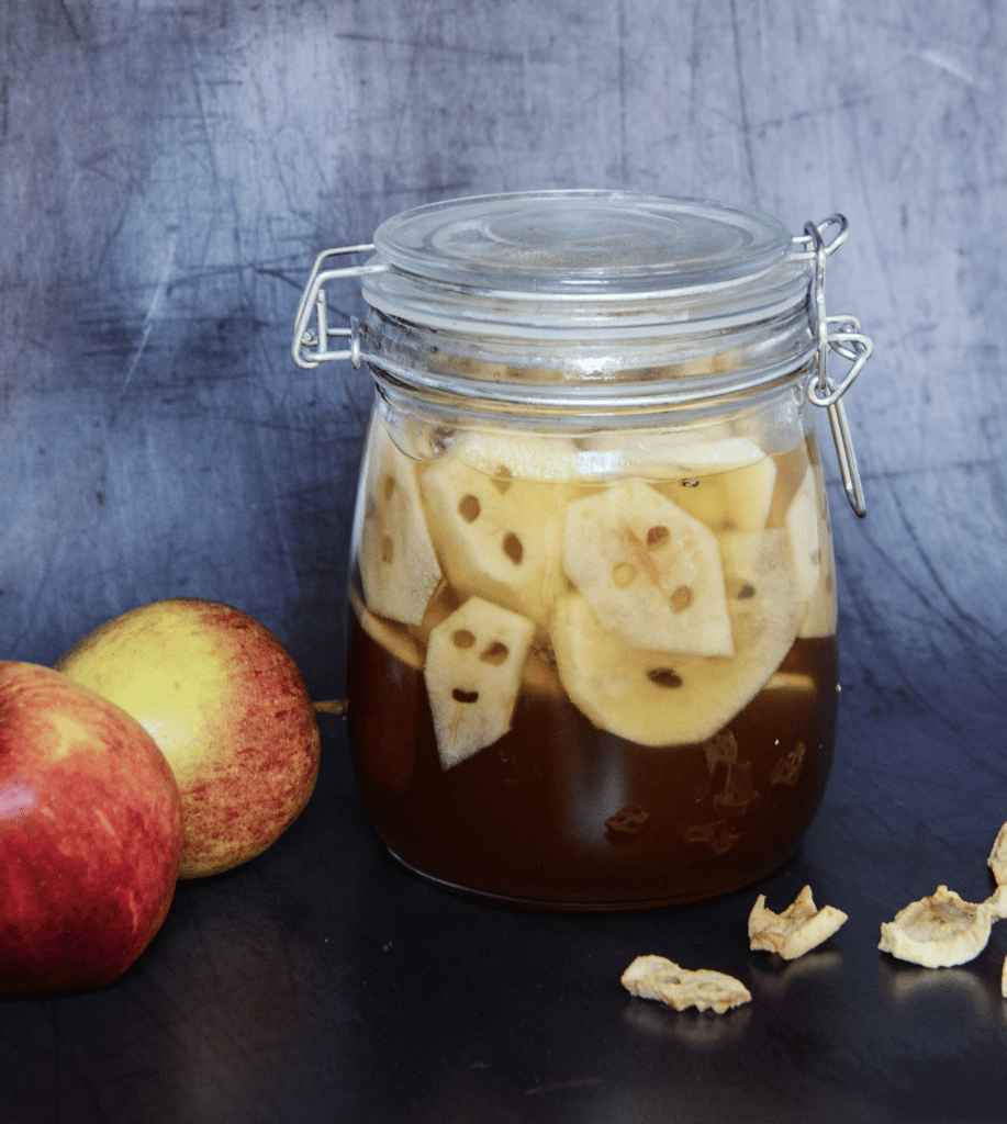 Calaveras de manzana en un frasco para Halloween.