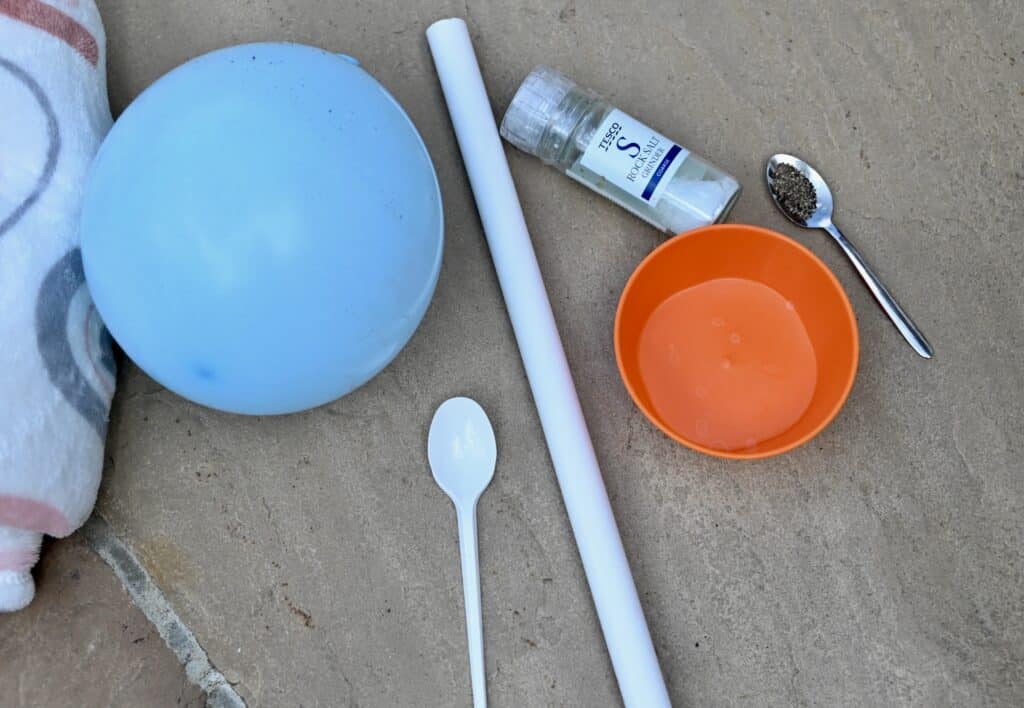 balloon, wool blanket, plastic spoon, PVC pipe, salt and pepper for a kitchen science activity