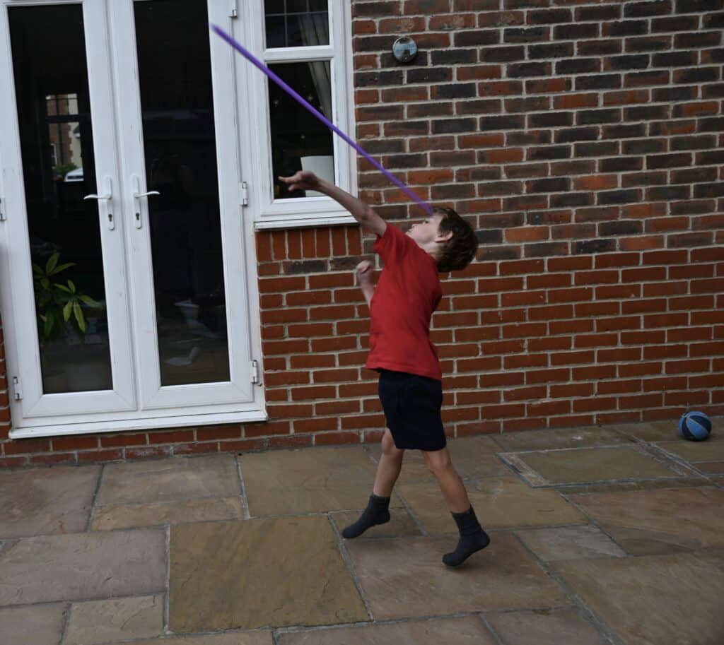 small boy throwing a paper javelin for a STEM challenge