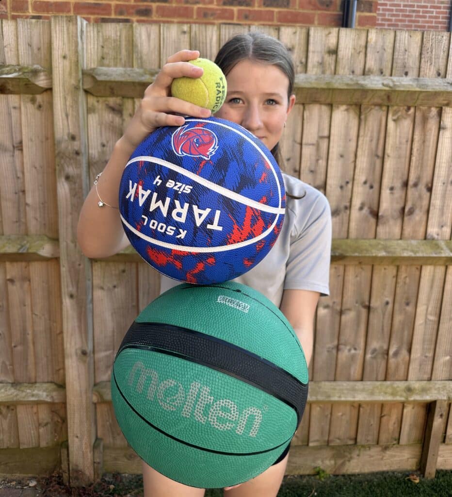 girl holding 3 different sized balls for a 3 ball stacked drop